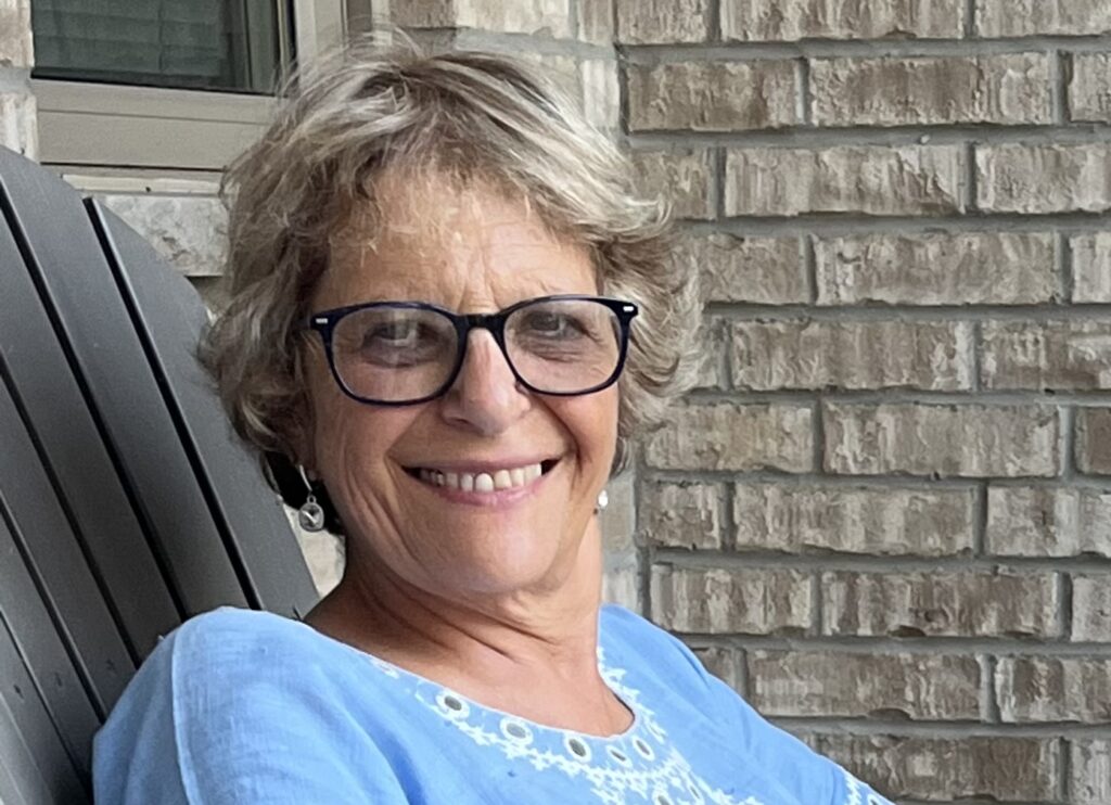 Adela sitting outside and smiling.